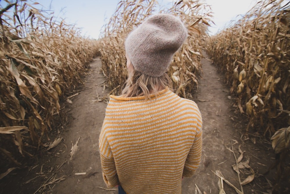 Woman choosing a path in a corn maze